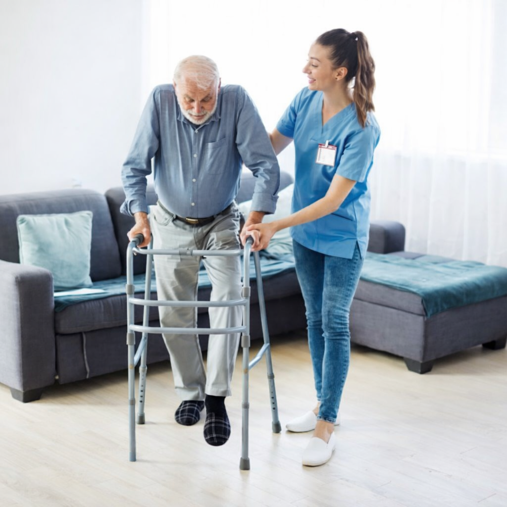 Adulto mayor recibiendo apoyo de movilidad con caminadora y acompañamiento profesional